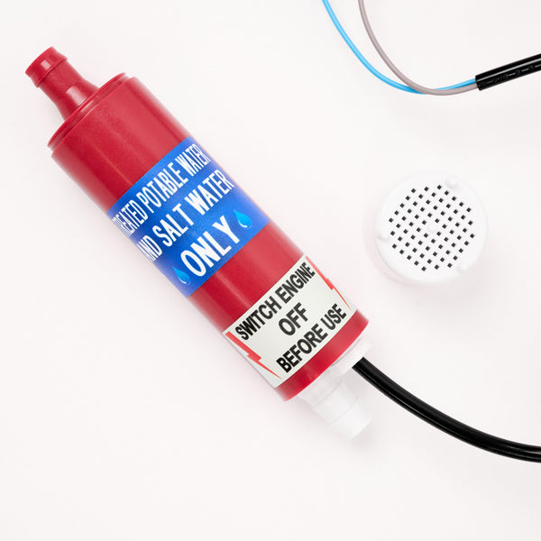 Red water pump labeled Filtered potable water and salt water only and Switch engine off before use, with connected wires and a white circular component nearby on a white background.