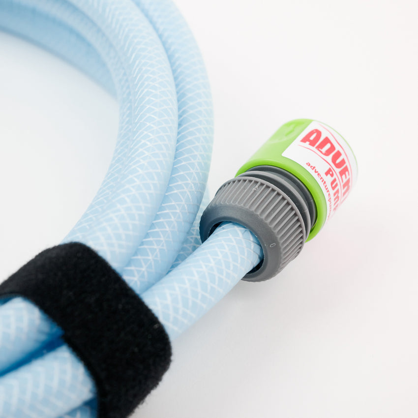 Close-up of the 1 x 5 meter extension hose inc fittings, coiled light blue with a green and gray ADVANCED connector. A black Velcro strap secures it, making it ideal for Adventure Pumps and compatible hose connectors.