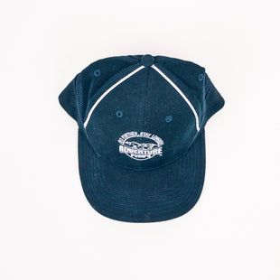 The Adventure Pumps Hat is a navy blue cap with white piping and Adventure Fun embroidered alongside a mountain graphic on the front. This stylish hat is shown against a white background.