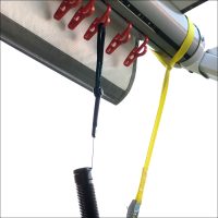 A close-up of a metal awning track with red clips, rolled fabric, a yellow strap, and black cord against a white background—perfect for use with Awning Hooks – 10 Pack – Suits Rollout Awnings.