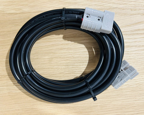 The 5 meter x 50 amp Anderson to Anderson electrical extension cable, coiled with gray connectors and secured by two black zip ties, is ready to power your Adventure Pump from any compatible source on a light wooden surface.
