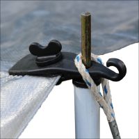 Close-up of a tarp secured with a Tarp Gripper – Each, attached by rope to a metal pole and a white pipe.