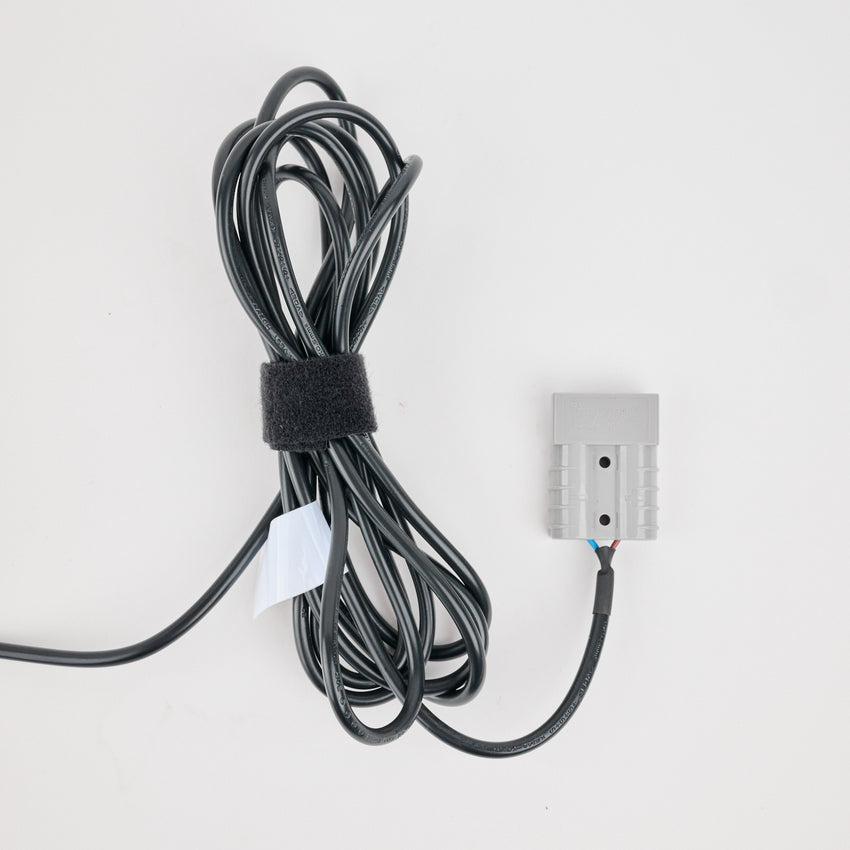 Coiled black cable with a metal connector on a white background