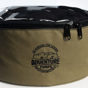 A round, olive-green zippered bag with a clear top holds the Adventure Pumps Universal 12V Water Transfer Pump Kit Bundle (WITH Canvas Bag), featuring the logo, Go further, stay longer!—perfect for carrying your pump and accessories on any journey.