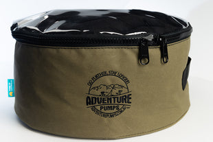 The Universal 12V Water Transfer Pump Kit Bundle (WITH Canvas Bag) comes in a round, olive green fabric bag with black zipper, clear top, Adventure Pumps mountain logo and motto on the front, plus a blue side tag—ideal for storing your kit.